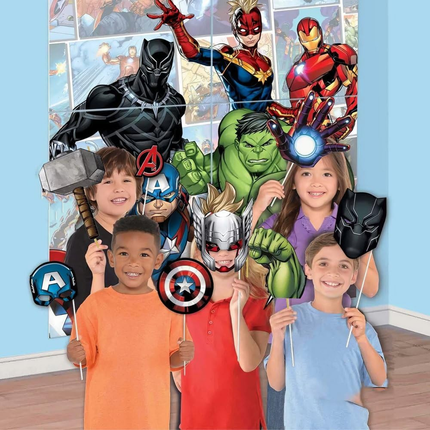 Children posing with superhero masks and costumes against a backdrop of superhero characters.