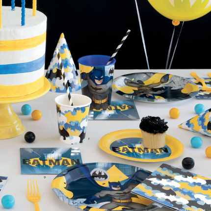 Batman-themed party table with cake, cups, plates, and decorations.