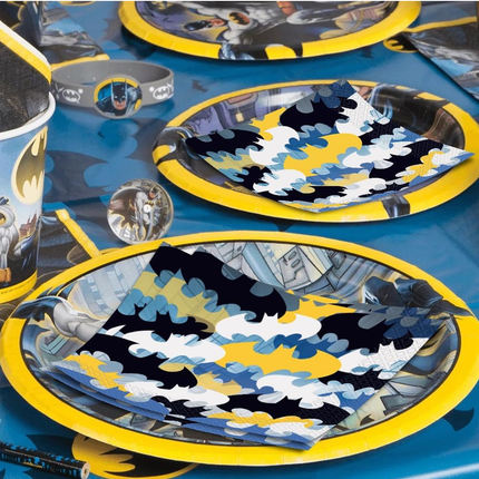 Batman-themed tableware including plates, cups, and napkins on a blue background.