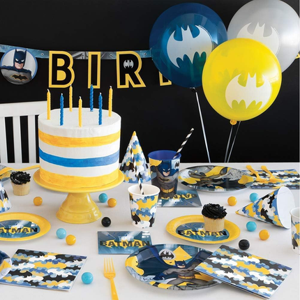 Batman-themed birthday party setup with cake, balloons, and tableware.