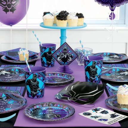 Black Panther-themed party table setting with plates, cups, and cake stand on a purple tablecloth.