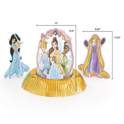 Three Disney princess party decorations on a gold fringed base, shown with dimension lines and labels: Jasmine, Cinderella, and Rapunzel. The center character is larger and stands in front of a pink castle mirror frame, while the left and right characters are smaller and flanking the center figure.