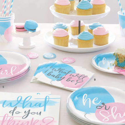 Gender reveal party supplies including plates, napkins, and cupcakes on a table.