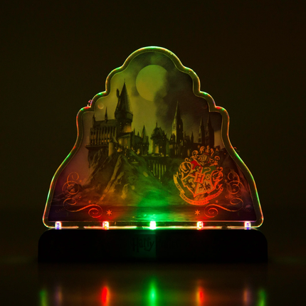 Decorative light with castle design and Hogwarts crest on a dark background