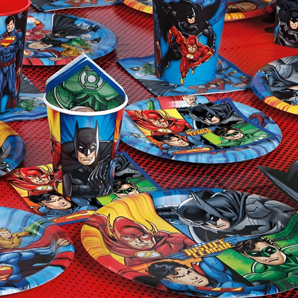 Superhero-themed party supplies including plates, cups, and napkins on a red checkered tablecloth.