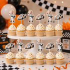 Twelve frosted cupcakes displayed on a white cake stand at a party, each topped with a custom baby racer cupcake topper. The toppers feature cartoon illustrations of babies in racing suits and their race cars.