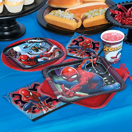 Spider-Man themed party supplies including plates, cups, and napkins on a blue tablecloth.