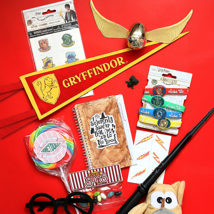 Collection of Harry Potter-themed items including a wand, lollipop, and Gryffindor banner on a red background.